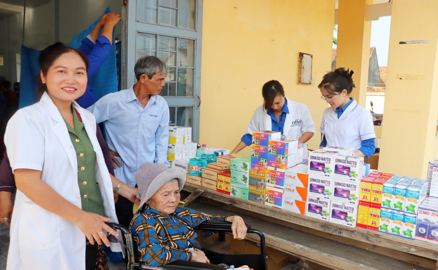 'A group of people standing around a table with boxes

AI-generated content may be incorrect.'